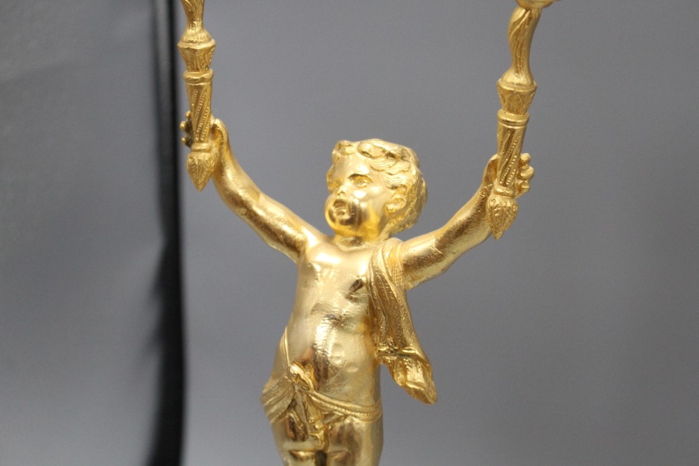 A pair of Italian gilt metal candelabra, with cherub stems and onyx bases, height 52cm